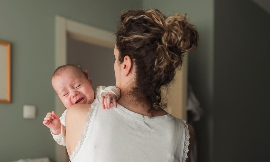 Woman taking car of a crying newborn baby