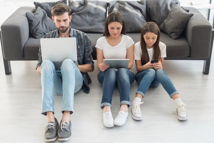 familia mirando ordenador, tablet y móvil