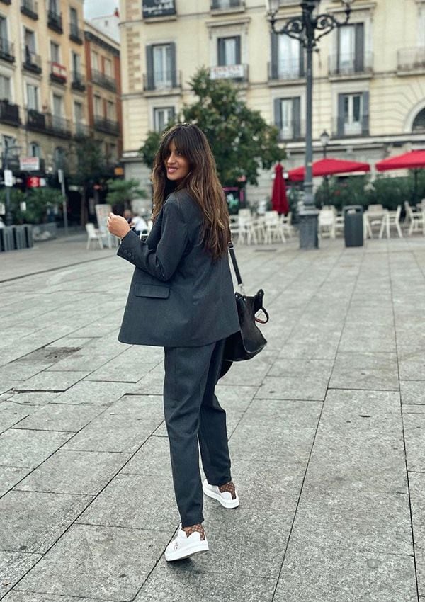 Sara Carbonero con traje gris y zapatillas deportivas blancas