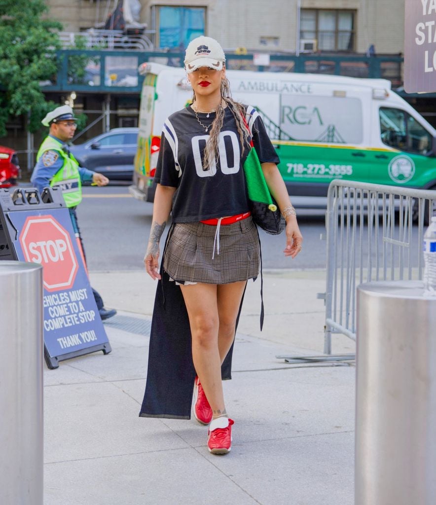 Rihanna lleva un jersey diseñado por Loewe y falda Miu Miu para el juego de AC Milan contra el Manchester City en Nueva York.
