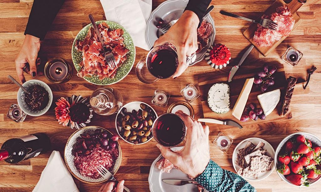 Mesa con diferentes platos y copas de vino