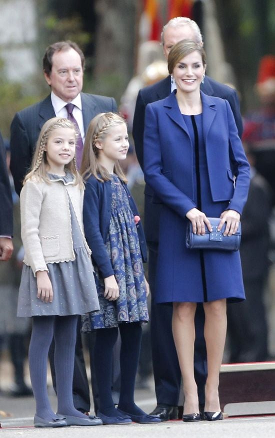 Doña Letizia, muy elegante con una chaqueta y vestido en doble crepe de lana azul marino con cinta en terciopelo azul noche de Felipe Varela, ha vuelto a ejercer de Reina y madre, ya que ha estado muy pendiente de la princesa de Asturias y la infanta Sofía en todo momento
