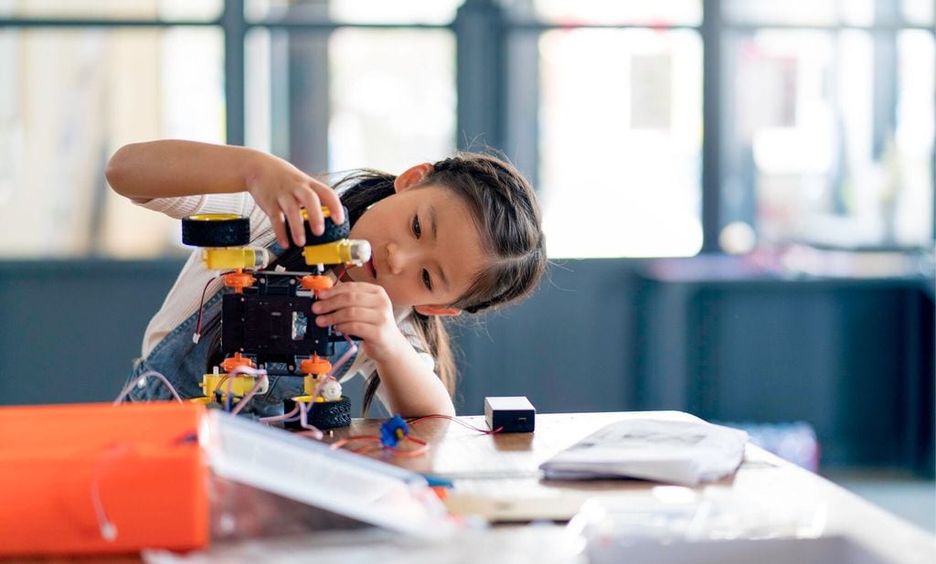 young girl working on a robot design