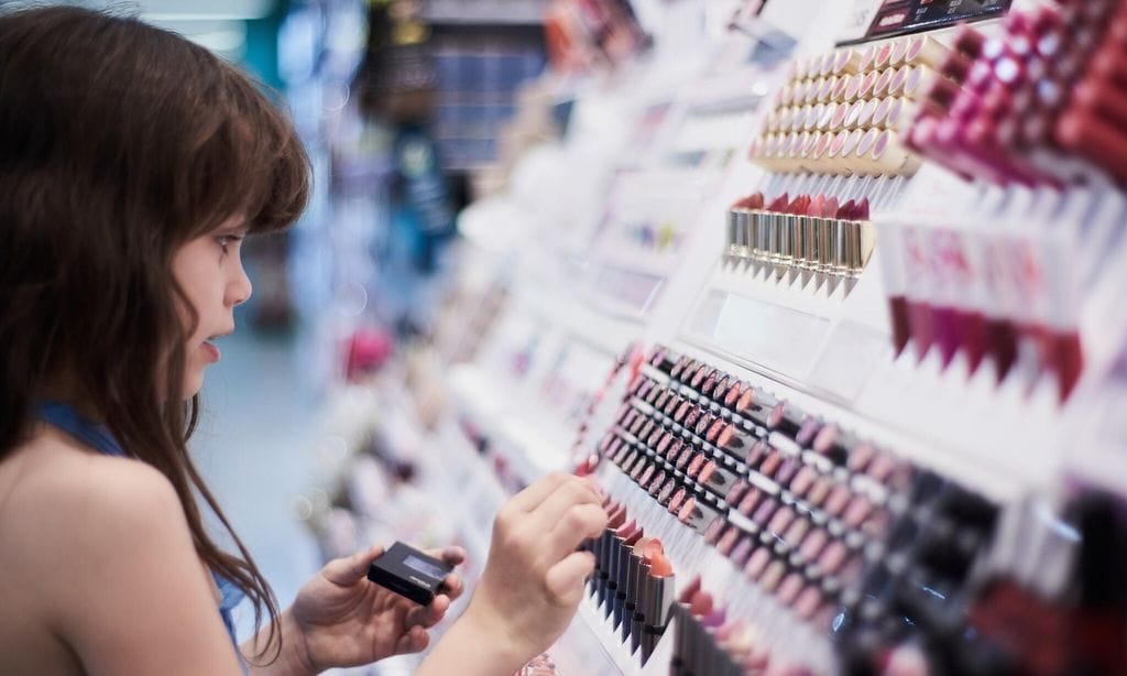 Niña compra maquillaje