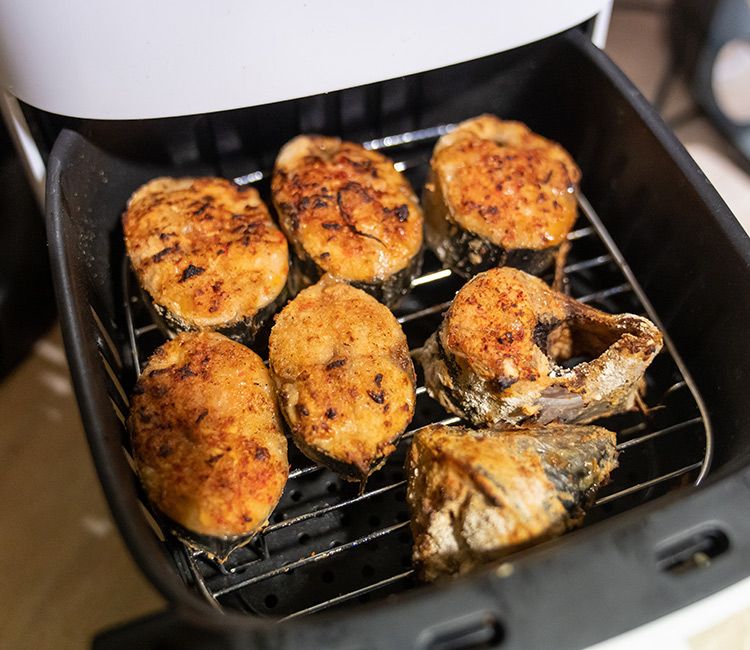 Rodajas de pescado rebozadas y fritas dentro del cestillo de la 'airfryer'