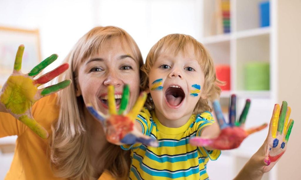 madre con su hijo con las manos y la cara llenas de pintura