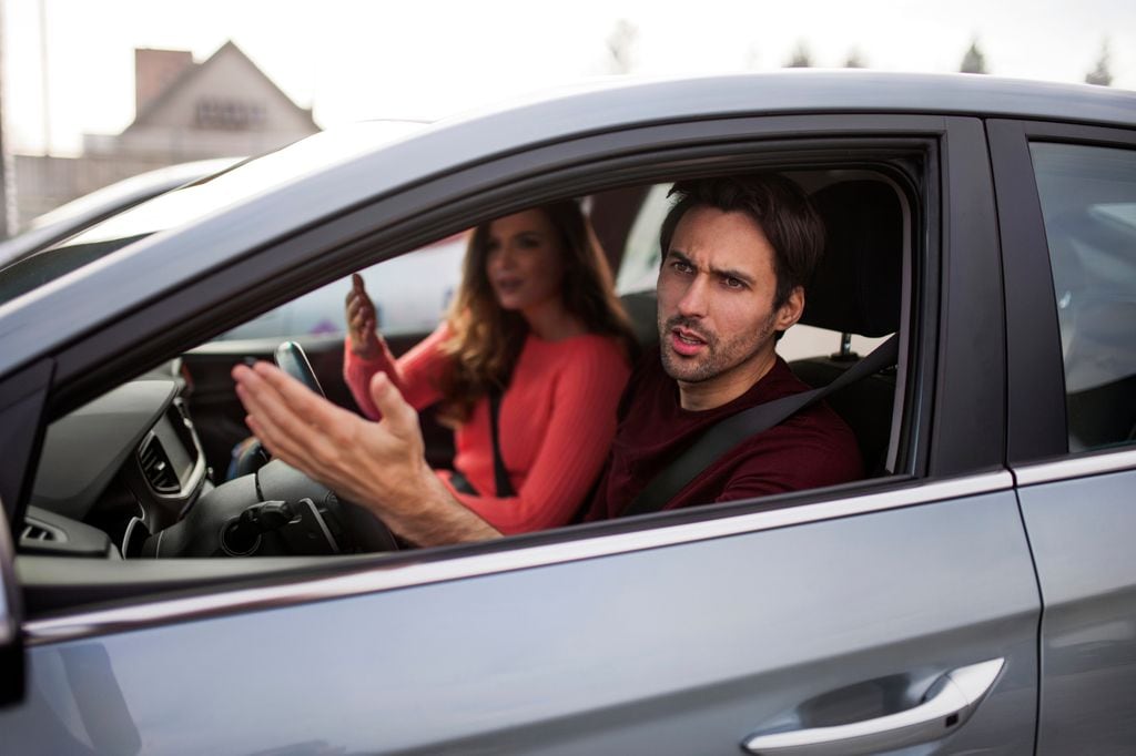 pareja en un coche, discutiendo con alguien