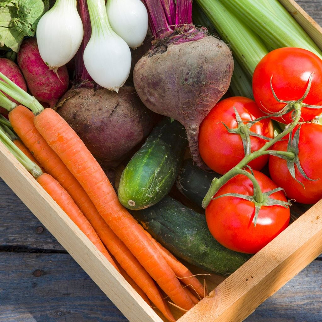 A wooden crate of fresh vegetables