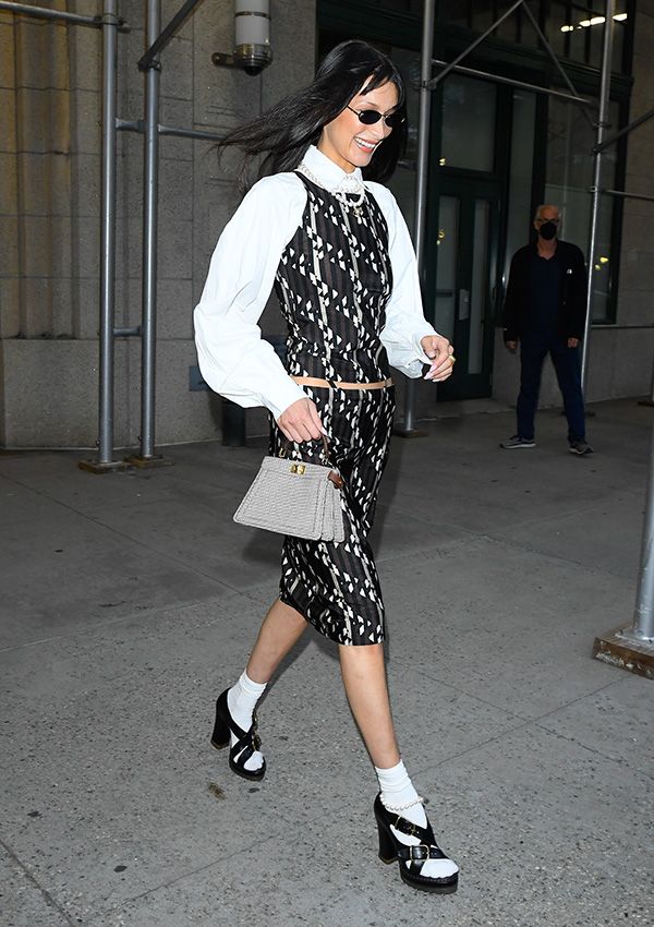 Bella Hadid con vestido bicolor, camisa blanca y sandalias de plataforma con calcetines