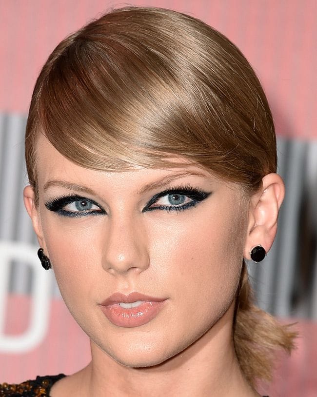 Taylor Swift no hace caso al lema 'menos es más' y arriesga con una mirada intensa y alargada gracias al perfilador y las sombras azules, combinadas con una base muy natural y labios con un toque de gloss
