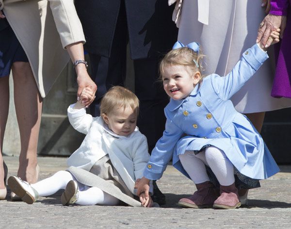 La princesa Leonore se bajó de los brazos de su madre para intentar caminar -está dando sus primeros pasos- pero terminó sentada en el suelo, fue entonces cuando su prima la princesa Estelle intentaba agarrar su manita que se pusiera en pie
