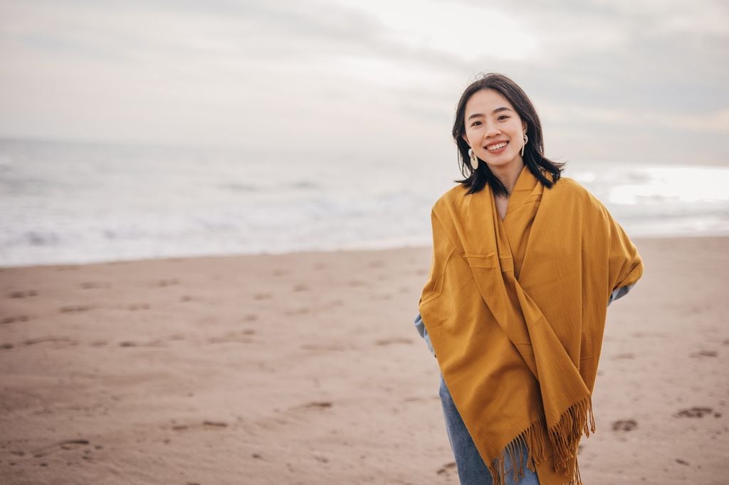 Mujer japonesa caminando en la playa