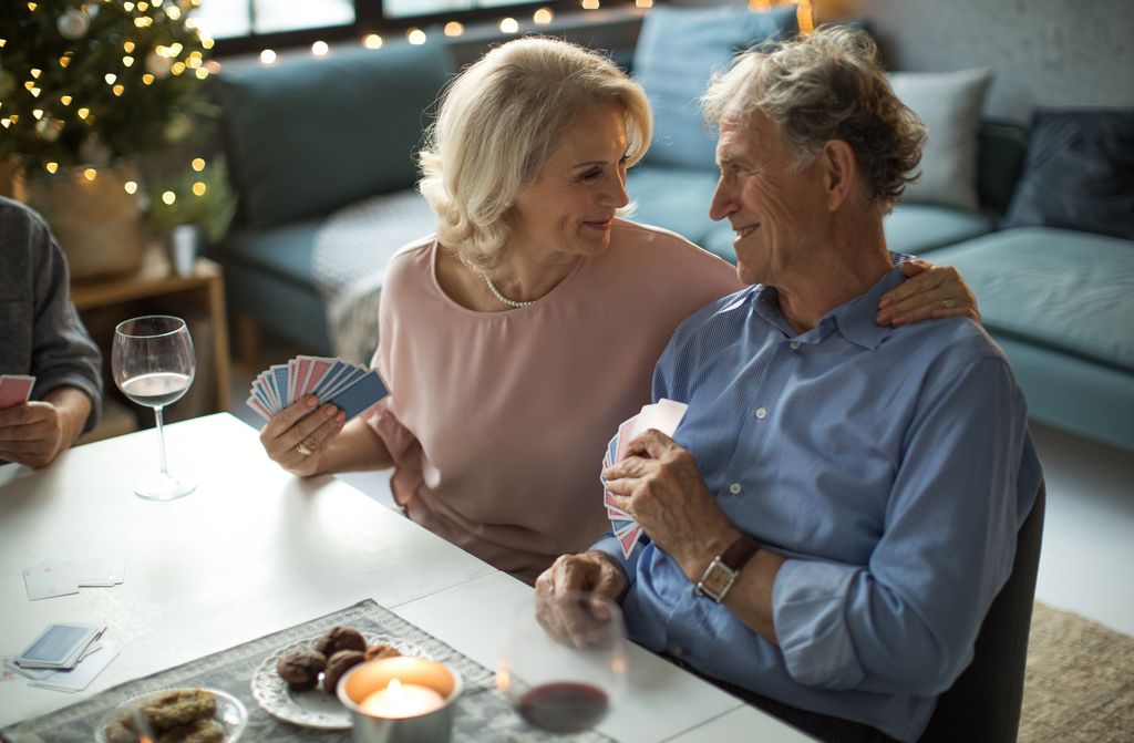 pareja madura jugando a las cartas en la sobremesa en Navidad