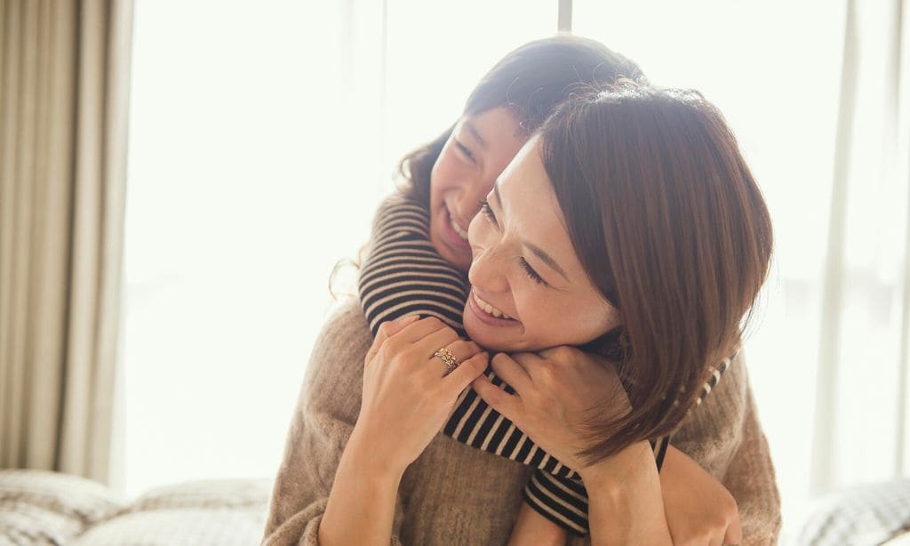 mother and daughter playing in bed room