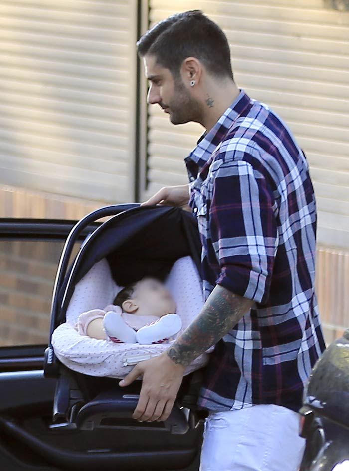 Melendi con su hija Lola, de siete meses, que duerme plácidamente en su maxicosi