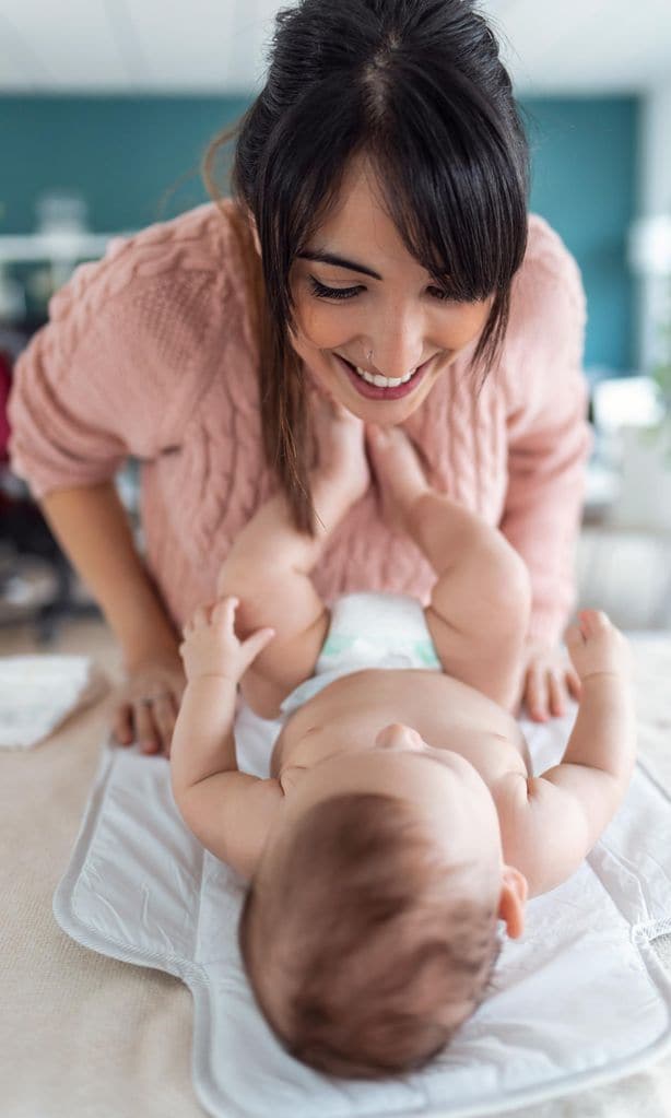 Mamá cambiando pañal a bebé