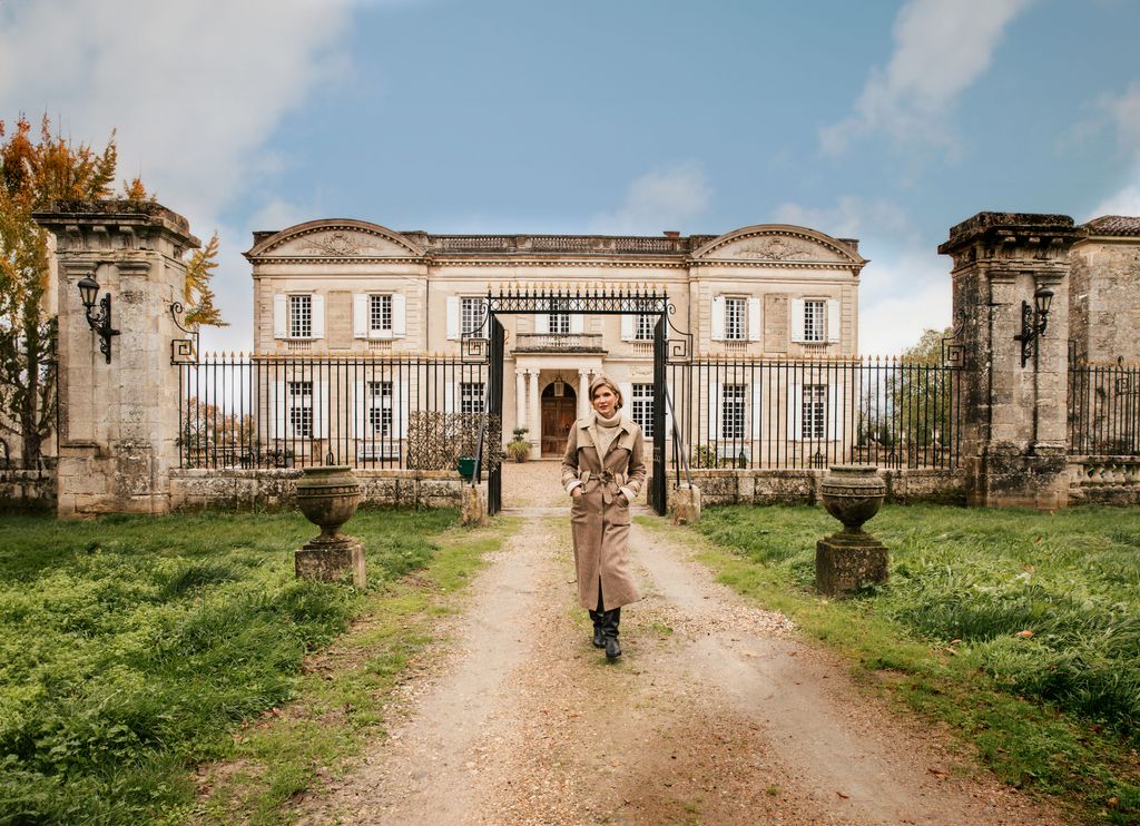 Catherine Roger posa con su castillo al fondo, situado en el municipio de Marcellus, en el departamento de Lot-et-Garonne, muy cerca de Burdeos.