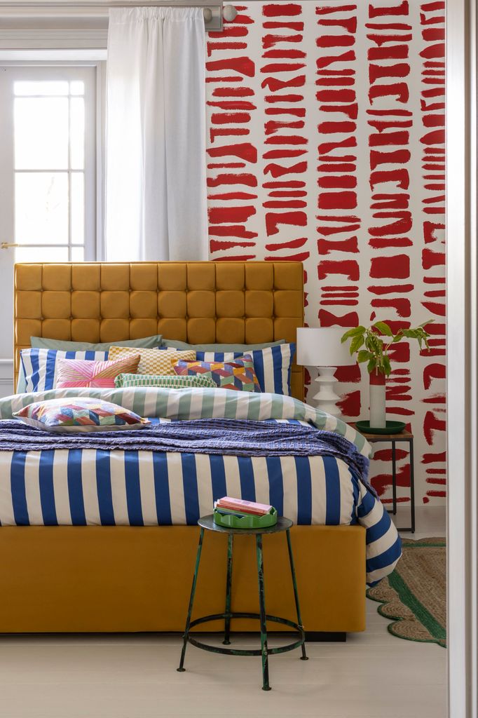 Dormitorio decorado en azul, rojo y mostaza