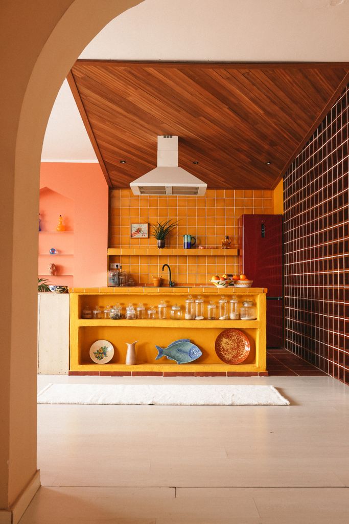 Cocina decorada con muebles y revestimientos en color amarillo yema de huevo