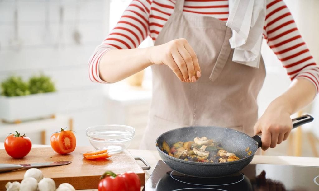 mujer cocinando de forma saludable