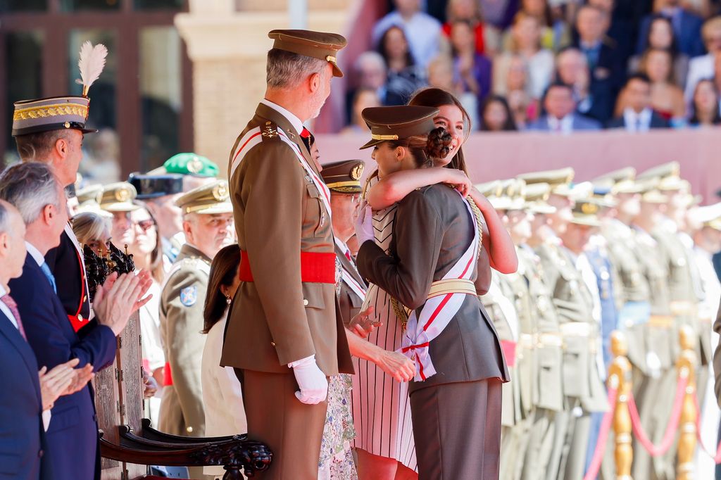 El rey Felipe mira con orgullo a sus dos hijas, la princesa Leonor y la infanta Sofía, dándose un abrazo durante la entrega de los despachos de empleo en la academia general militar de Zaragoza, el 3 de julio de 2024