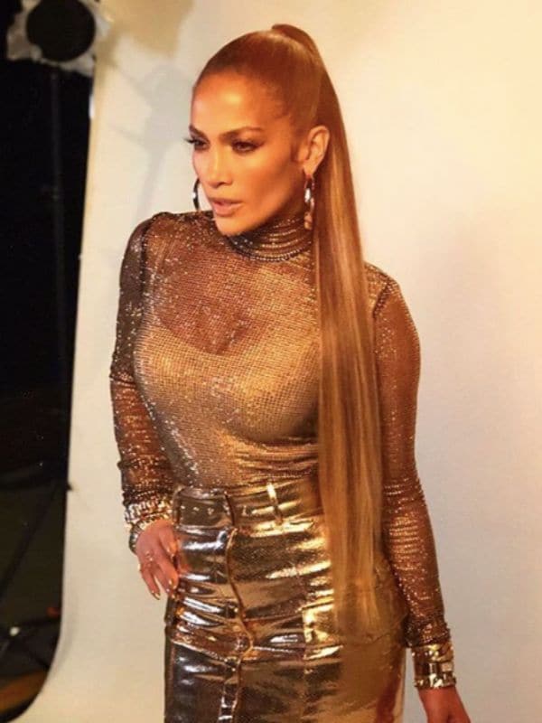 Jennifer Lopez con cola alta y extensiones XL con atuendo dorado 