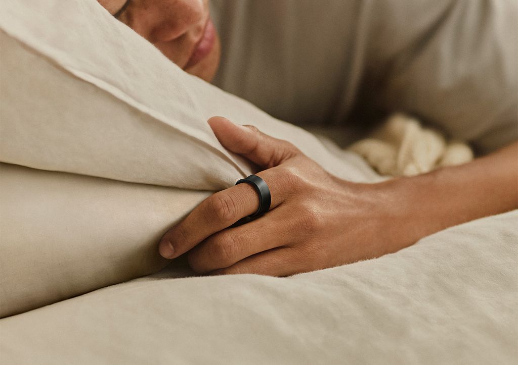 Una persona durmiendo con un anillo inteligente en la mano