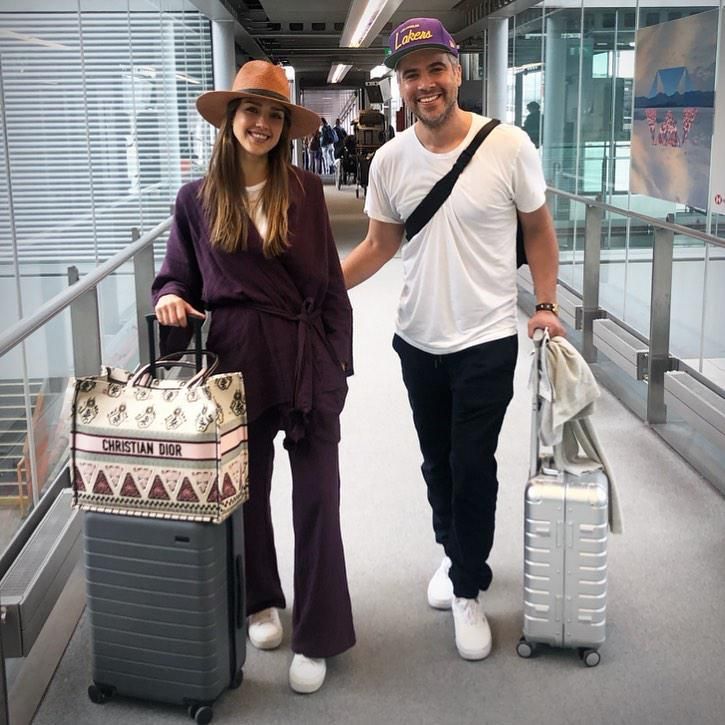 jessica alba y su esposo en un aeropuerto con maletas