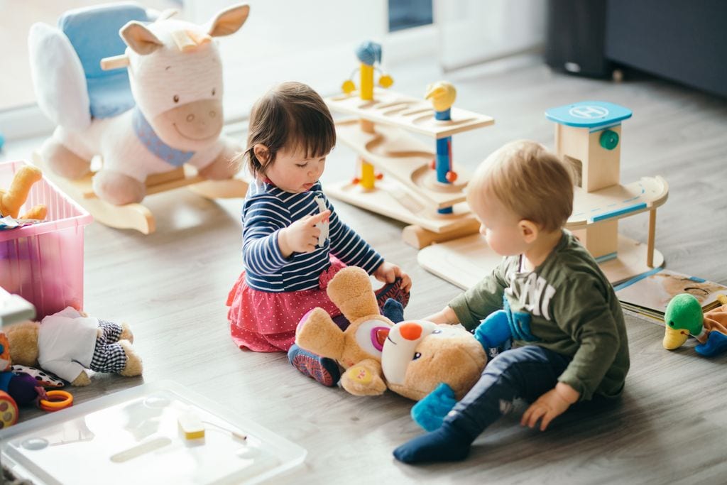 Bebés jugando con un oso de peluche