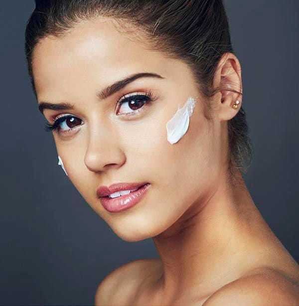 mujer morena con crema en las mejillas