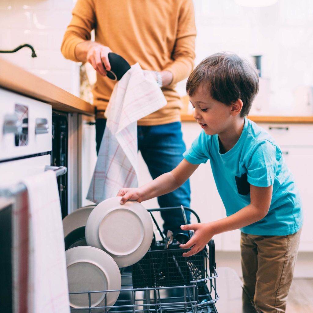 Niño ayudando en las tareas del hogar a su madre.