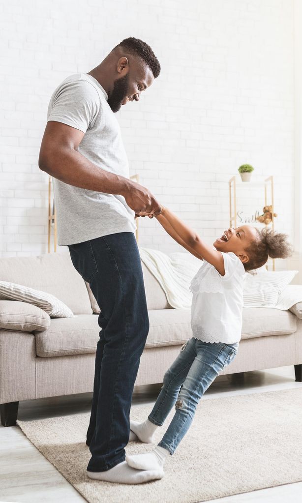 Padre e hija bailando en casa