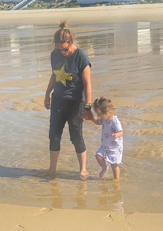 Imagen de Toñi Moreno caminando por la playa junto a su hija