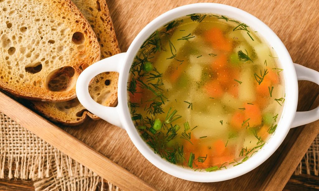 sopa de pollo en un taz n blanco en bandeja de madera 