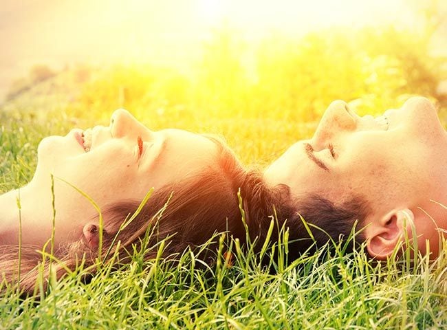 jóvenes tumbados al sol sonriendo