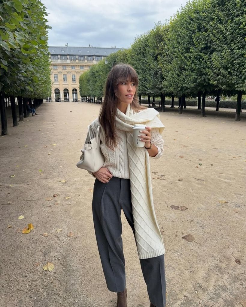 Influencer con jersey blanco y pantalones grises en París