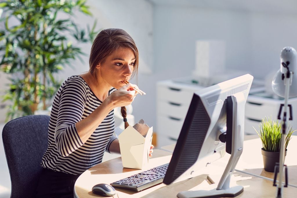 Mujer comiendo en la oficina 