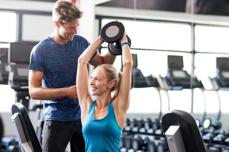 mujer pesas entrenador