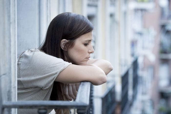 mujer seria mirando por la ventana