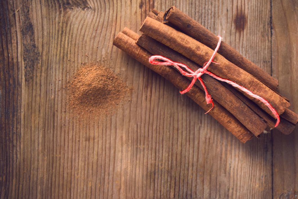 Cinnamon sticks and cinnamon powder on wooden table