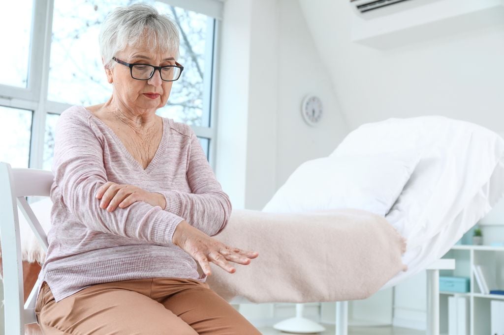 mujer sujetando su brazo para evitar que tiemble