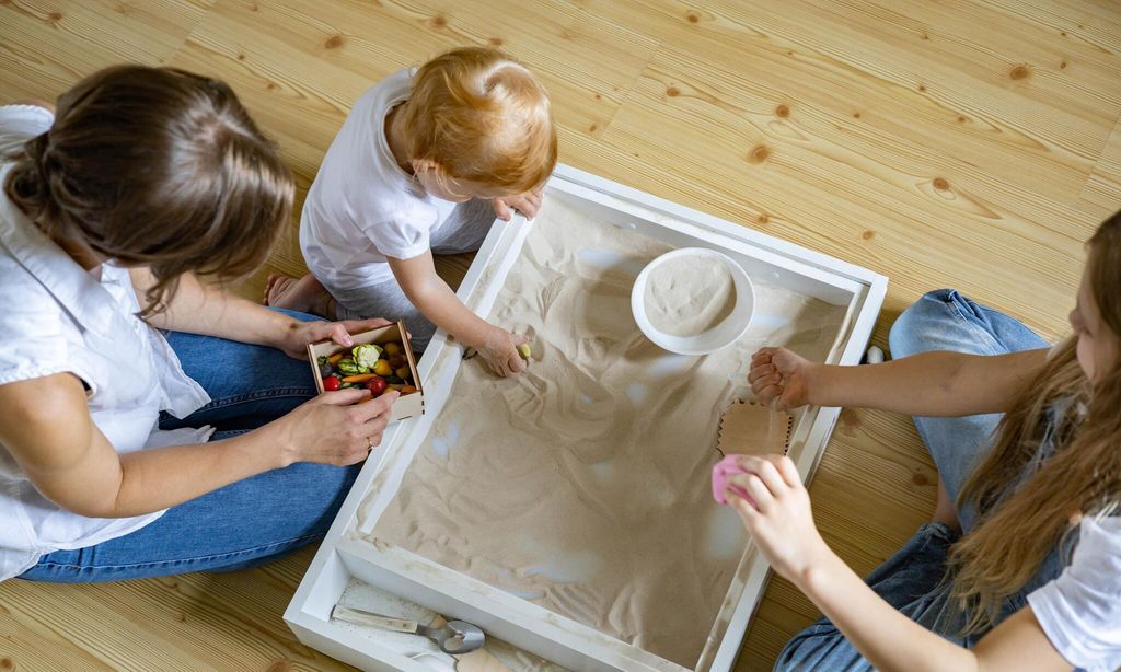 enthusiastic family playing home kinetic sandbox use wooden ecological toys enjoying leisure