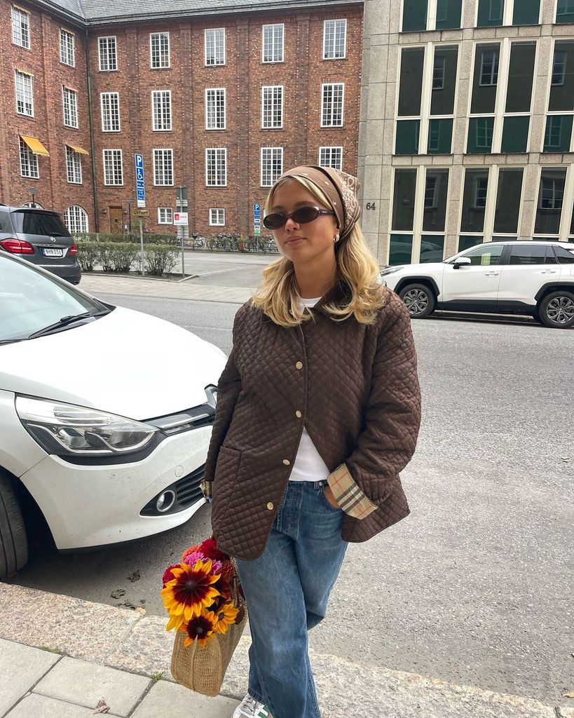 Matilda Djerf con abrigo guateado, camiseta básica, vaqueros y zapatillas