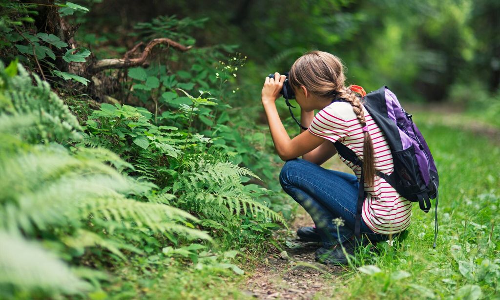 little girl taking photos in the forest