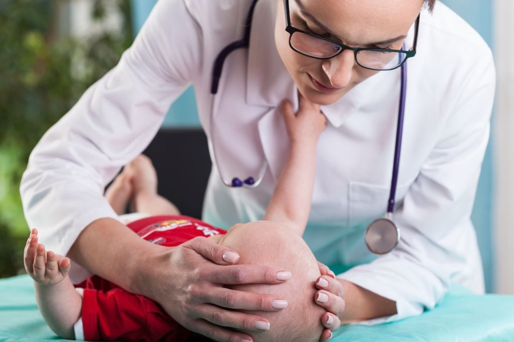 Médico explorando la cabeza del bebé