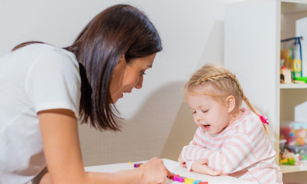 madre jugando sobre una mesa con su hija