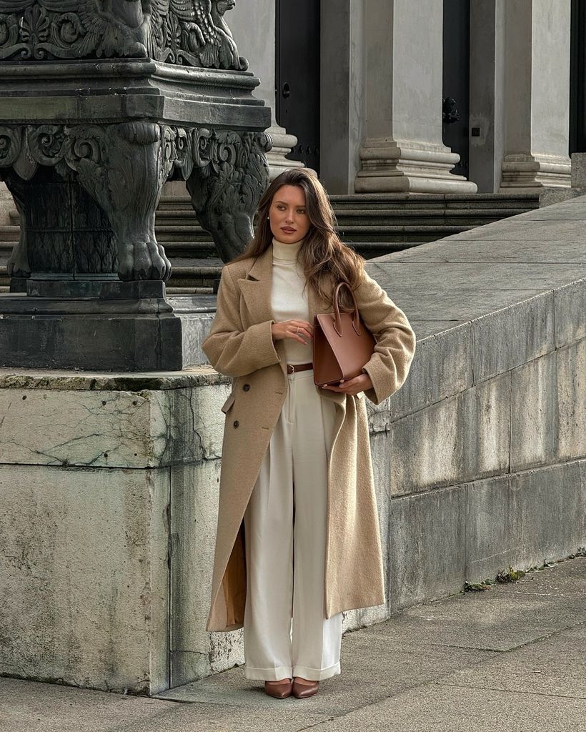 Influencer con abrigo marrón y conjunto blanco