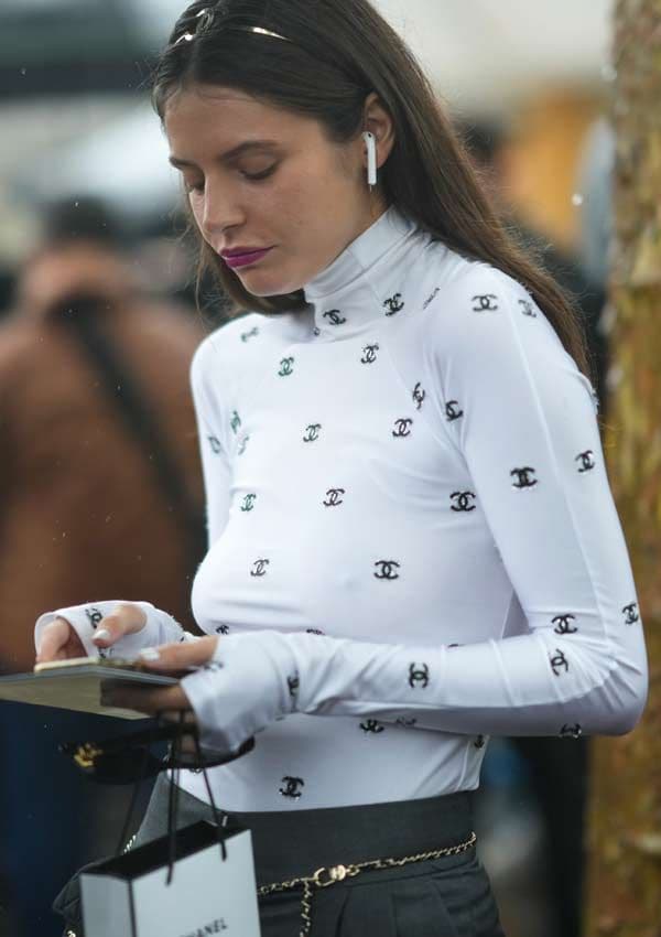 Mujer con top de Chanel y auriculares inalámbricos