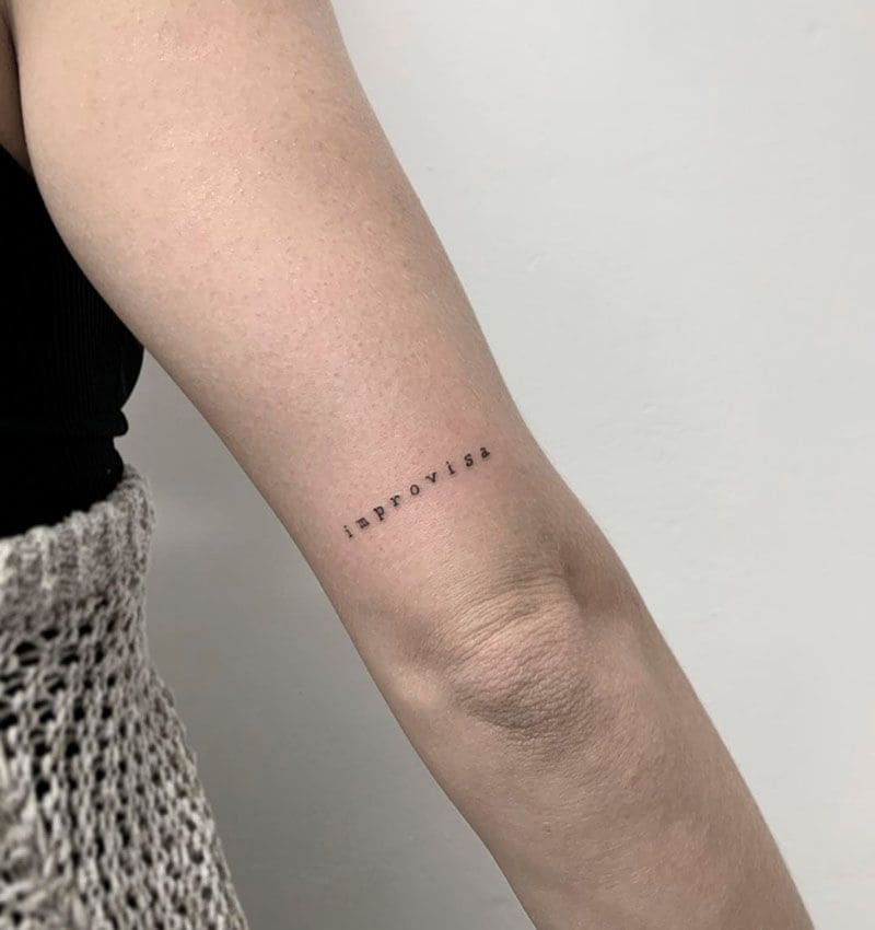 Tatuaje de letras encima del codo