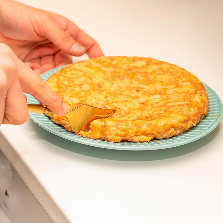 Cortando tortilla de patata recién hecha